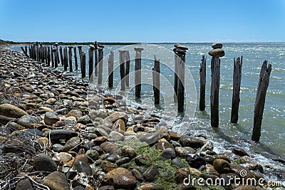 Balanced stones and wooden piles at the Galabert lake in the Camargue in Provence France Stock Photo