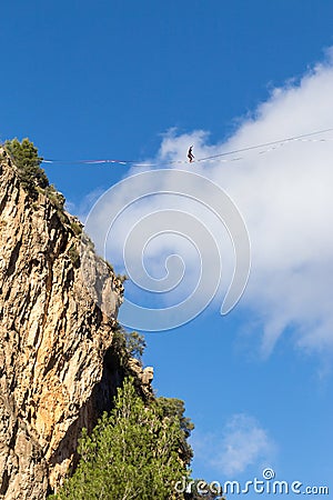 Balancing on a slackline from a steep cliff Stock Photo