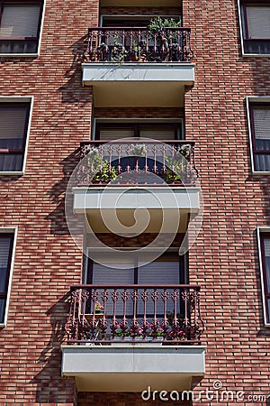 Balconies with the flowers of a multi-story apartment house Stock Photo