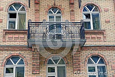 Balcony on the brick wall of the building and many windows Stock Photo