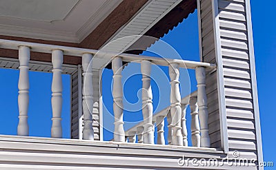 Balcony detail with carved marble balusters - railing and wooden wall cladding. Stock Photo