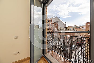 Balcony of a house with metal railing with grid and window in gray Stock Photo