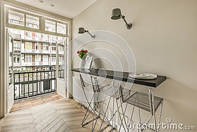 a kitchen with a bar and a balcony with chairs Stock Photo