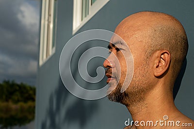 Bald beard 40s portrait man on blue wall cement background Stock Photo