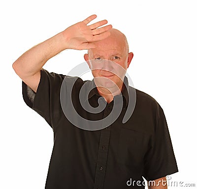 Bald headed man shielding eyes Stock Photo