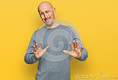 Bald man with beard wearing casual clothes disgusted expression, displeased and fearful doing disgust face because aversion Stock Photo