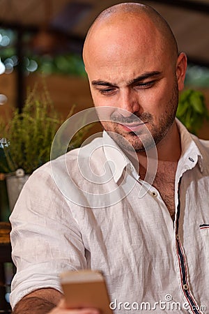 Bald Man Looking at His Phone Stock Photo