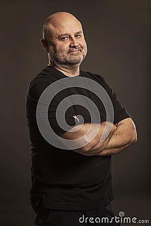 Bald middle-aged man, dark background Stock Photo