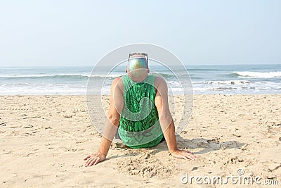 A bald and unusual young man, a freak, with a shiny bald head and round wooden glasses on the background of the beach and the sea Stock Photo