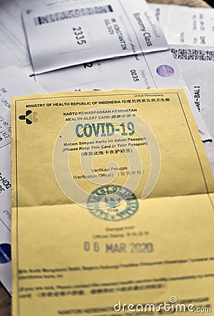 BALI, DENPASAR- MARCH 05, 2020: Indonesia health alert card for the absence of coronavirus disease on the background of airline ti Editorial Stock Photo