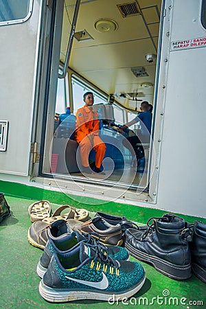 BALI, INDONESIA - APRIL 05, 2017: Different shoes waitting outside of the ferry boat pilot command cabin with view on Editorial Stock Photo