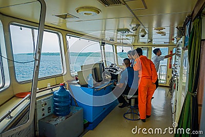 BALI, INDONESIA - APRIL 05, 2017: Ferry boat pilot command cabin with the captain operating the machines with a many Editorial Stock Photo