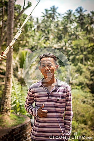 BALI, INDONESIA - DECEMBER 5, 2017: Closeup portrait of asian balinese indonesian man in the jungle of Bali island. Editorial Stock Photo