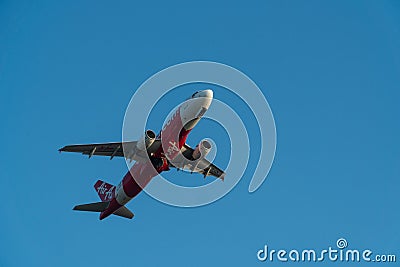 BALI/INDONESIA-JUNE 06 2019: Air Asia, one of the airlines in Indonesia, is flying over the blue sky. Landing gear is in the Editorial Stock Photo