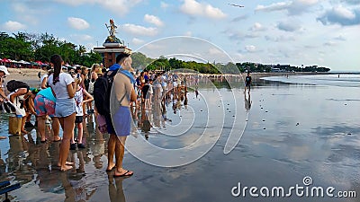 BALI, INDONESIA - Kuta beach visitors take part in the activity of releasing baby turtles into the sea Editorial Stock Photo