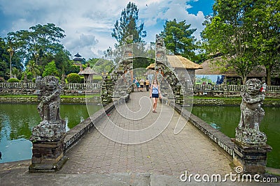 BALI, INDONESIA - MARCH 08, 2017: Unidentified woman walking inside of the temple of Mengwi Empire located in Mengwi Editorial Stock Photo