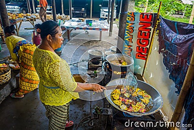 BALI, INDONESIA - MARCH 08, 2017: Women preparing an Indian Sadhu dough for chapati on Manmandir ghat on the banks of Editorial Stock Photo