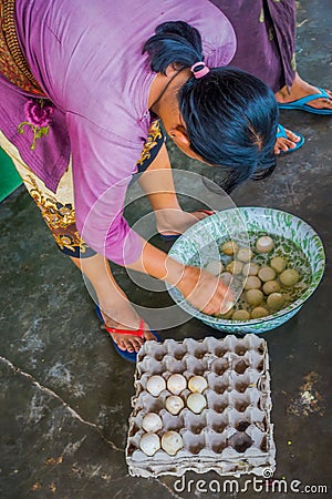 BALI, INDONESIA - MARCH 08, 2017: Women preparing an Indian Sadhu dough for chapati on Manmandir ghat using a turtle Editorial Stock Photo