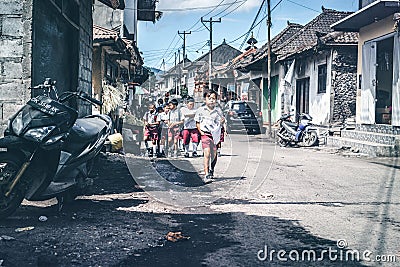 BALI, INDONESIA - MAY 23, 2018: Group of balinese schoolboys in a school uniform on the street in the village. Editorial Stock Photo