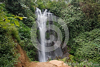 Bali's Waterfall in Long Shutter Grace, Brown Ground and Lush Greenery Stock Photo