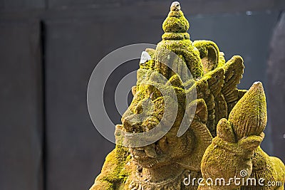 Balinese Carved Stone Statue of Rakasa covered with green moss.Thailand Stock Photo