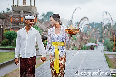 balinese couple wearing traditional clothes walking together in bali Stock Photo