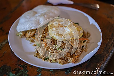 Balinese dinner served in a white plate with mixed seafood friedrice and egg Stock Photo