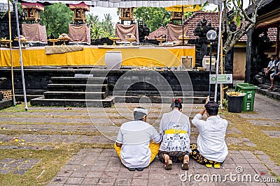 Balinese family dressed in a traditional costumes praying in Pura Goa Lawah Balinese Editorial Stock Photo