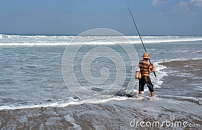 Balinese Fisherman Surf Casting on Legian Beach. Editorial Stock Photo