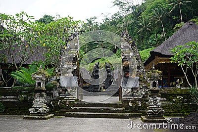 Balinese temple carved in stone gate entrance with plants Stock Photo