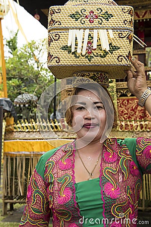 Balinese woman bringing offerings to temple Editorial Stock Photo