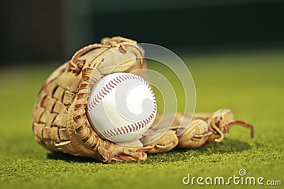 Baseball ball in glove ob grass background Stock Photo