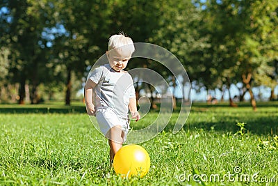 Concentrated small boy kicking a ball in the garden Stock Photo