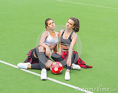 With the ball on the football field two sports girls. Stock Photo