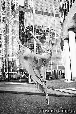 Ballerina, ballet dancer on modern city background. Attitude position. Stock Photo
