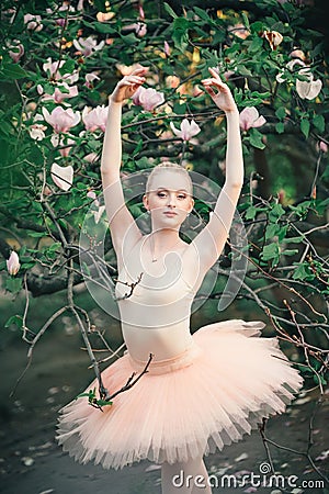 Ballerina dancing outdoors classic ballet poses in flowers lands Stock Photo