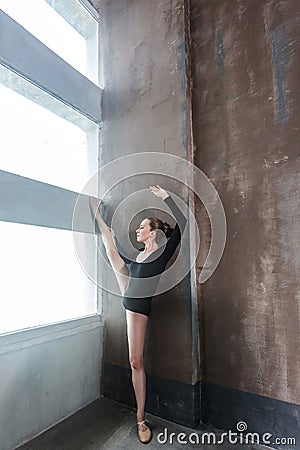 Ballerina doing aerobic exercise near sunlight window. Stock Photo