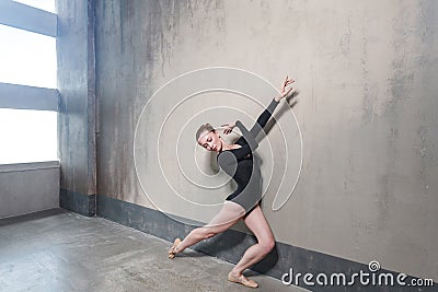 Ballerina movement in classic ballet posing near window Stock Photo