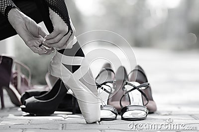 Ballerina Putting Pointe Ballet Shoes on her Feet Stock Photo