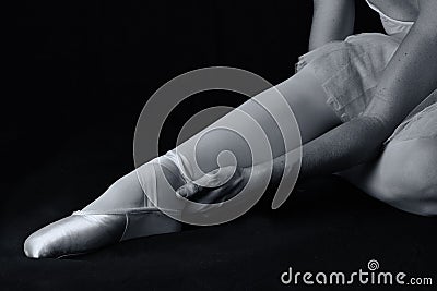 Ballerina sit down on floor to put on slippers Stock Photo
