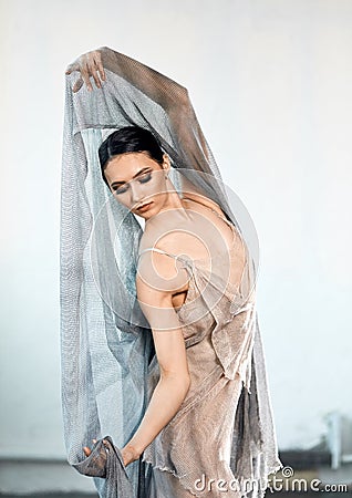 Ballerina in stage long transparent costume dancing modern ballet. Stock Photo