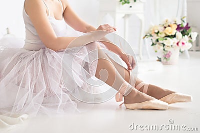 Ballerina tying pointe ballet shoes. Close up Stock Photo