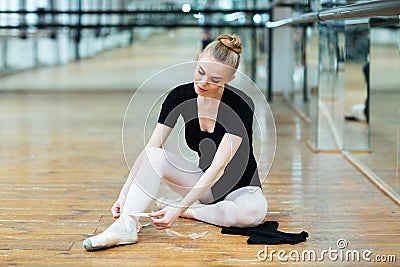 Ballerina tying pointe shoes Stock Photo