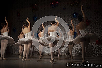 Ballerinas in white tutus show dance movement. The girls are doing ballet. Ballet dance class on stage. There are many girls in Editorial Stock Photo