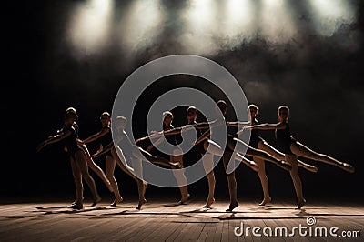 Ballet class on the stage of the theater with light and smoke. Children are engaged in classical exercise on stage. Stock Photo