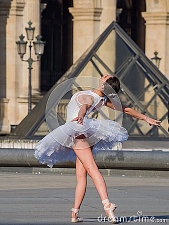 Ballet dancer dancing in front of the famous Louvre Museum Editorial Stock Photo