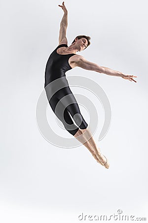 Ballet Dancer Young Man in Black Dance Suit Posing in Flying Ballanced Dance Pose Studio Stock Photo