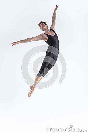 Ballet Dancer Young Man in Black Dance Suit Posing in Flying Ballanced Dance Pose Studio Stock Photo