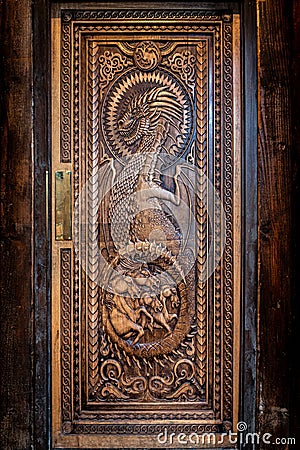 BALLINTOY HARBOUR, NORTHERN IRELAND, DECEMBER 20, 2018: Magnificent carved door with dragons and Dothraki horses, made with wood Editorial Stock Photo