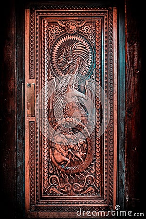 BALLINTOY HARBOUR, NORTHERN IRELAND, DECEMBER 20, 2018: Magnificent carved door with dragons and Dothraki horses, made with wood Editorial Stock Photo